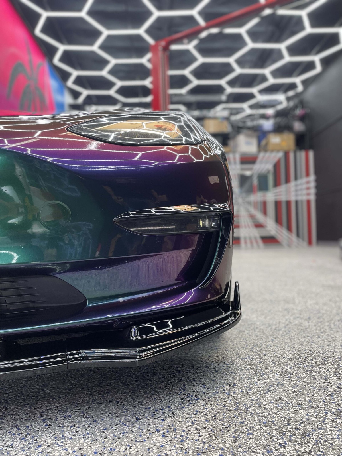 Color-shift wrapped Tesla in the Nikola Customs bay